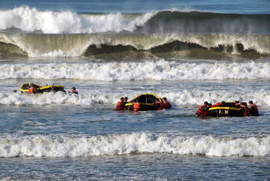 Navy SEALS in rafts in pounding surf